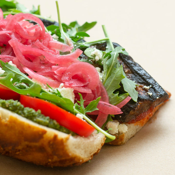 An open hoagie-style sandwich with roasted eggplant, tomatoes, arugula and picked red onion | Rōzmary Kitchen